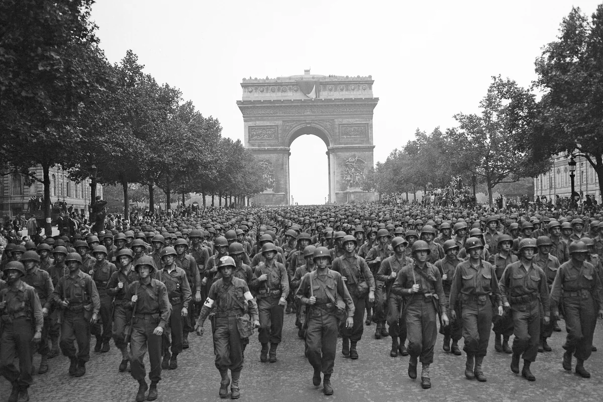 Des soldats américains défilent sur les Champs-Élysées devant l’Arc de triomphe, à Paris, le 29 août 1944